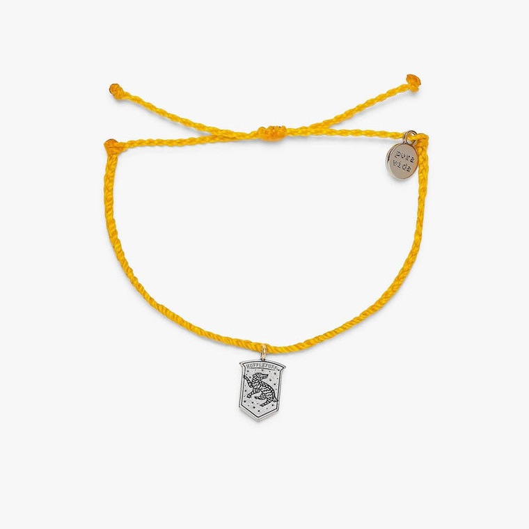 Earn (cool) points for your favorite house with our Hufflepuff™ Crest Charm Bracelet! Set on a yellow bitty braid band, this enchanting design features a dangling crest charm, with a Hufflepuff™ badger etched on the front and “dedication, patience, loyalty” on the back. For every bracelet sold, Pura Vida will donate 5% of the purchase price to the World Literacy Foundation, with a maximum donation of $25,000. Your donations will help further the World Literacy Foundation’s mission to ensure that every child—regardless of geographic location—has the opportunity to acquire literacy skills and books to reach their full potential!