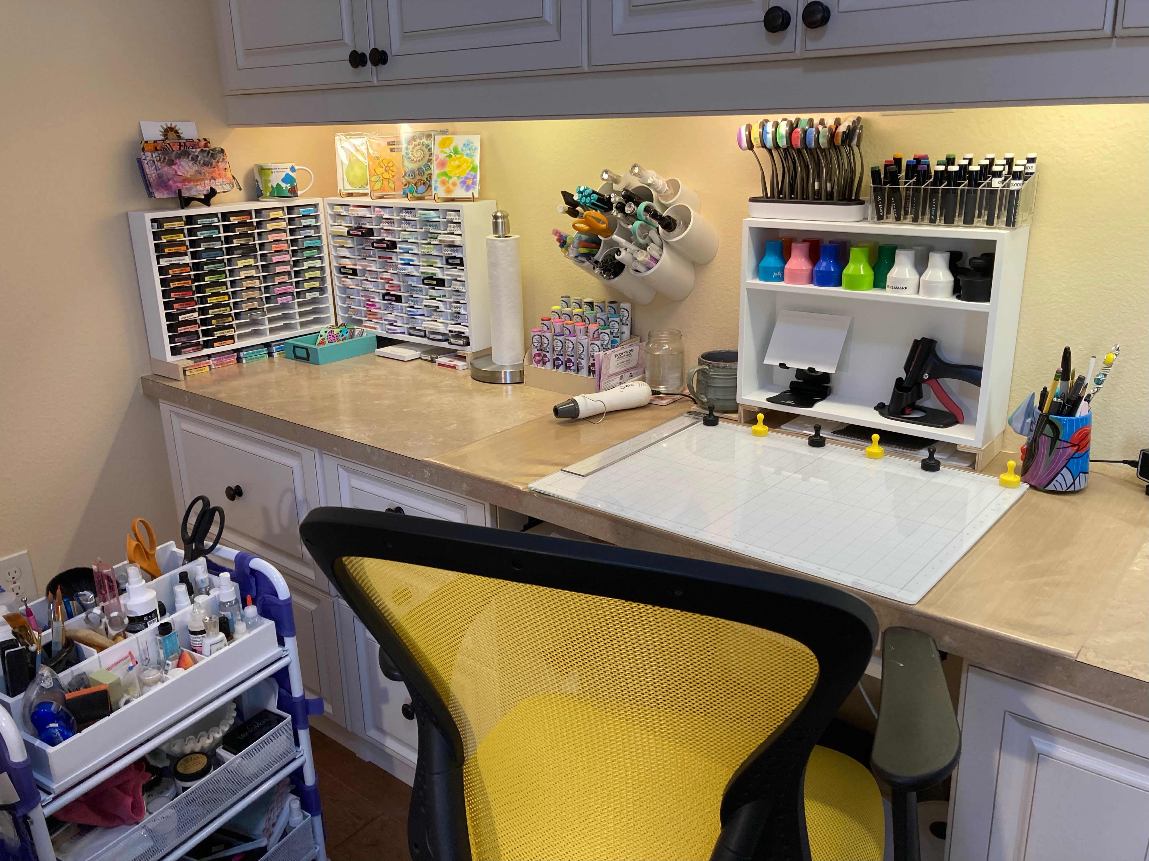 Desk with yellow chair, card making surface, blending brushes, markers, ink pads, and cards