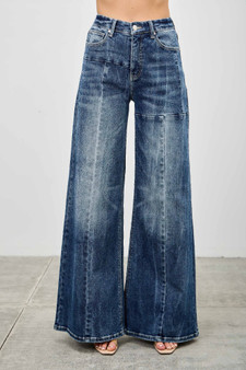 Woman wearing high-waisted wide leg jeans in dark acid wash with front seam detail.