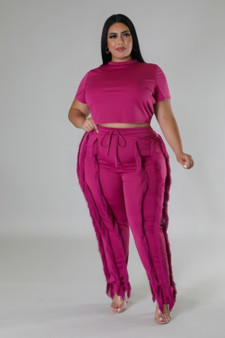 Two-piece monochromatic magenta coordinates featuring a cropped tee and tiered fringe trousers with drawstring waist.