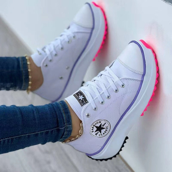 Women's white canvas platform sneakers featuring electric purple piping and a chunky neon pink lug sole.