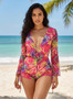 Full-length view of a floral print 3-piece beach ensemble with flared bell sleeves and a deep V-neckline against a turquoise ocean backdrop.