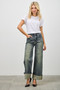 A front view of high-waisted denim trousers featuring a dramatic wide-leg silhouette and thick, folded cuffs at the ankle. The fabric has a unique distressed finish with subtle yellowish-green undertones.