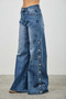 Boutique denim: high-rise wide-leg jeans with decorative and functional side buttons.