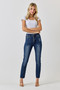 Front view of a person wearing high-waisted dark wash skinny jeans. The jeans feature an exposed bronzed five-button fly, light whiskering at the hips, and a small distressed tear near the left pocket. The legs end in raw, frayed hems at the ankle.