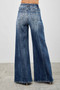 High-waisted palazzo style denim pants in distressed dark indigo.