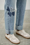 "Streetwear style light wash jeans featuring decorative denim star patches and raw hems."