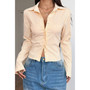 "Fitted ribbed button-up shirt with pointed collar and structured sleeves."