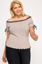 A blonde model wearing a tan and black horizontal striped off-the-shoulder top featuring black lace trim and adjustable ties on the sleeves.
