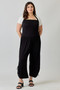 Full-length view of a plus-size model in a black cropped wide-leg jumpsuit.