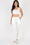 "A feminine lounge set consisting of a textured rib-knit crop tank and slim-fit joggers with a drawstring closure and tapered legs, styled with white slip-on sneakers."