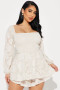 Elegant cream-colored romper with textured floral patterns and poet sleeves.