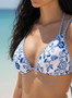 Front view of a blue floral V-neck bikini top and matching high-cut bottoms on a beach background.