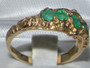 The ring holds five natural emeralds. These stones are frequently graduated in size, with the largest in the center.