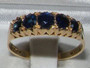 "Vintage 18ct yellow gold five stone sapphire ring with oval cut blue gemstones in a multi-claw setting."