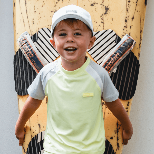 boy smiling at camera wearing a lime and white tshirt