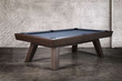 Three-quarter view of the Doc & Holliday George pool table in Antique Coffee on a concrete floor studio backdrop