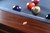 Close-up view of the double-diamond mother-of-pearl billiard sights set into the walnut rail of the Doc & Holliday Preakness pool table.