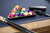Close-up of the Plank & Hide Deco 8FT Slate Pool Table in Glazed Maple showing Championship Academy Blue felt, golden brass diamond sights, and the Sawyer Twain Trophy billiard ball set