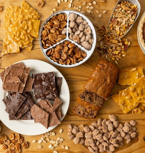 Selection of products from the Koinonia bakery including granola, pecans, chocolate, banana bread, brittle and pie.