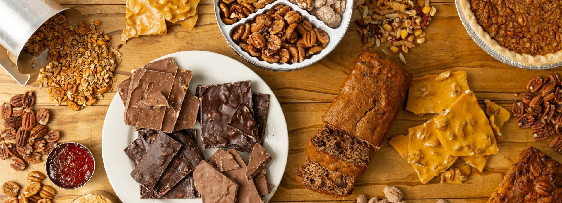 Selection of products from the Koinonia bakery including granola, pecans, chocolate, banana bread, brittle and pie.