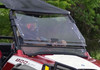 SuperATV flip out windshield closed on a red and white Polaris RZR, front three-quarter view