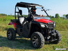 SuperATV flip windshield tilted open on a red Honda Pioneer 500 with a driver, side three-quarter view in a field