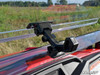Close-up of the SuperATV flip windshield hinge and latch bracket on the red Honda Pioneer 500 hood