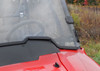 Close-up of the SuperATV full windshield lower edge and side clamp meeting the red Honda Pioneer 700 hood