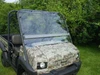 Extreme Metal Products full windshield installed on a camo Kawasaki Mule 4010, front three-quarter view on grass