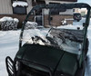 Extreme Metal Products clear hard windshield installed on a green Kawasaki Mule 600/610, front view over the hood in snow