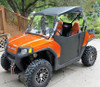 Trail Armor debris shields on an orange Polaris RZR, black lower door panels, front three-quarter view