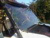 Extreme Metal Products full windshield on a white Polaris RZR, side view with the cage clamp and autumn trees