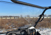 Driver seat view through the SuperATV full windshield over the green Kawasaki Teryx dash and hood
