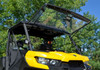 Front three-quarter view of the yellow Can Am Defender with the SuperATV windshield flipped fully up under the roof