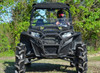 SuperATV sport front brush guard installed on a black Polaris RZR with mud tires, front view with a driver