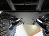 View under the Can-Am Maverick Trail showing both Trail Armor front A-arm guards installed