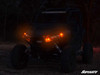 Side-by-side at night with the SuperATV turn signal kit amber lights lit, front three-quarter view