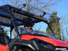 SuperATV flip windshield in the open position on a red Honda Pioneer 1000, front three-quarter view