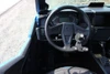 Close-up of the Sure Grip hand control lever and steering wheel in a blue side-by-side, showing the push-pull handle