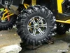 Close-up of a SuperATV Intimidator all-terrain tire on a chrome wheel mounted on a yellow side-by-side