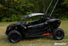 SuperATV nerf bars in black on a black Can-Am Maverick X3 with orange arms, side profile in a field