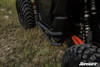 Close-up of the SuperATV nerf bar tube installed below the Maverick X3 door between the tires