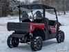 Rear three-quarter view of the red Yamaha Wolverine X2 in snow with the SuperATV rear windshield installed