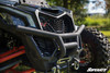 Low front view of the SuperATV winch ready bumper and winch shackles under the grille of a Can-Am Maverick X3