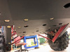 Underside of a Honda Talon 1000R on a lift showing Trail Armor trailing arm guards beside the skid plate