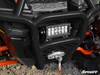 Black SuperATV front bumper with an LED light bar and winch fairlead on a Polaris General, close-up