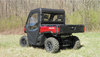 Passenger side rear view of a red Can-Am Defender fitted with the 3 Star vinyl windshield cab enclosure