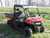 3 Star black soft top installed on a red side-by-side with a cargo bed, front three-quarter view on grass