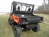 3 Star soft back panel with rolled-up rear window on an orange Honda Pioneer 1000, rear three-quarter view in a field